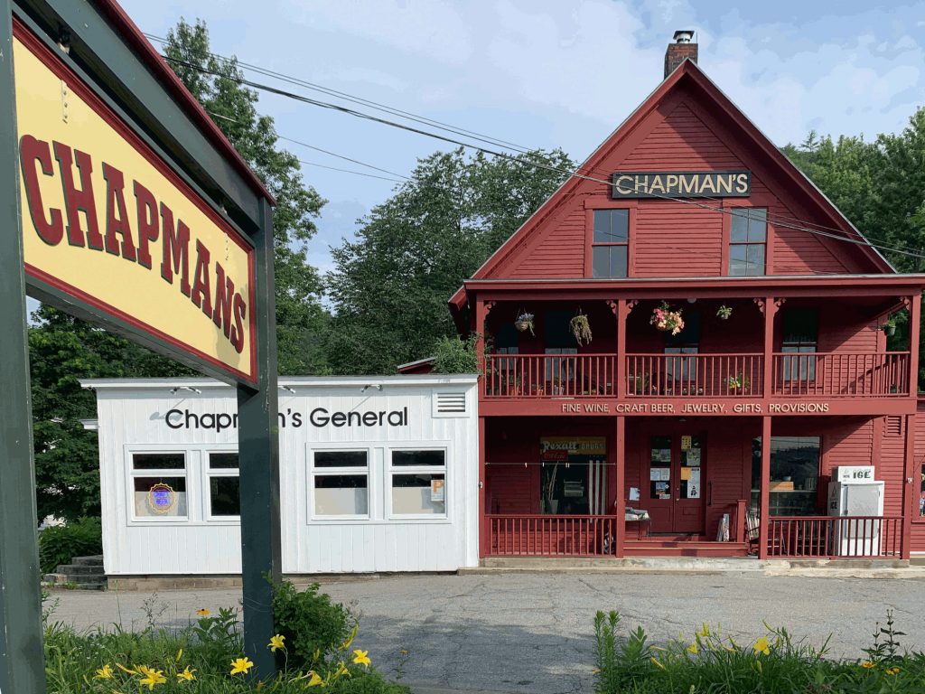 Front of store a red building with gold text on black banner